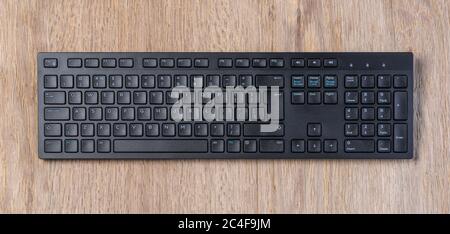 Top view of Full size wireless desktop computer keyboard on wooden table, with clipping path Stock Photo