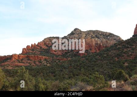 Red sandston and white limestone mountain covered with  many evergreen trees on the Devil's Bridge Trail in Sedona, Arizona, USA Stock Photo