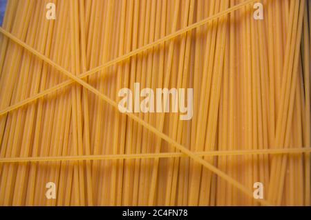 Dried egg spaghetti form a texture with a vertical line pattern useful for gastronomic backgrounds Stock Photo