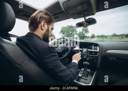 Businessman driving car and using gps navigation on mobile Stock Photo