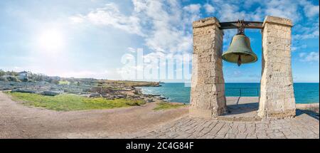 Big bronze bell on the sea shore in the ancient Greek city Chersonesus, Hersones in Sevastopol, Crimea. Copy space. Travel and relax concept. Stock Photo