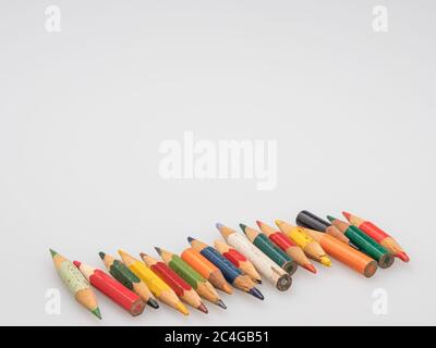 The remains of old colored pencils. Little pencils on a white background. Stock Photo