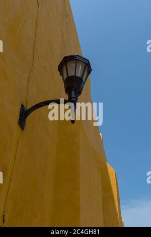 Street lamp on a yellow house wall in Campeche, Mexico Stock Photo