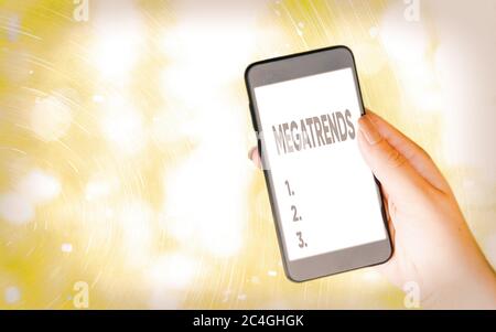 Handwriting text writing Megatrends. Conceptual photo global patterns related to behavior mobility and environment Modern gadgets with white display s Stock Photo