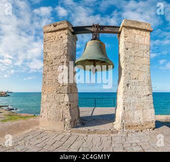 Big bronze bell on the sea shore in the ancient Greek city Chersonesus, Hersones in Sevastopol, Crimea. Copy space. Travel and relax concept. Stock Photo