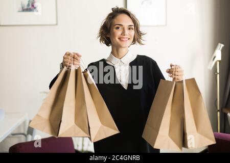Young beautiful smiling woman with short curly hair in black dre Stock Photo