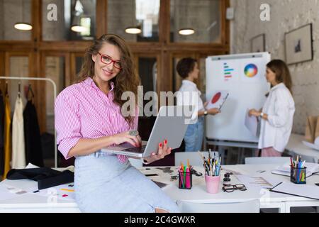 Young pretty smiling woman in striped shirt and denim skirt and Stock Photo