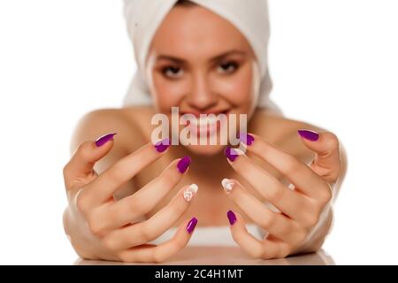 beautiful young woman with a towel on her head showing her manicure Stock Photo