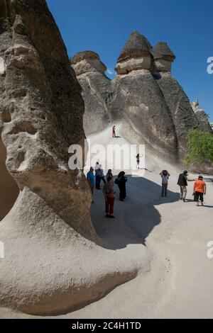 Tourists admire the unique fairy chimney landscape at Pasabagi near Zelve in the Cappadocia region of Turkey. Stock Photo