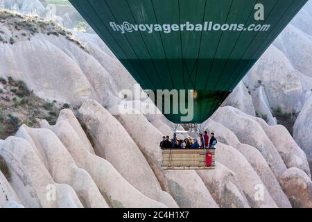 Passengers aboard a hot air balloon enjoy an early morning ride through the landscape surrounding the village of Goreme in Turkey. Stock Photo