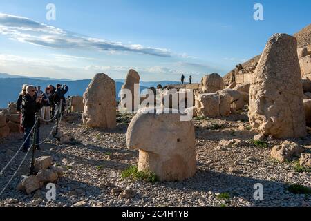 Tourists at the western platform at Mount Nemrut in Turkey. Stone statues located here include a Persian eagle god , Hercules , Antiochus and Zeus. Stock Photo