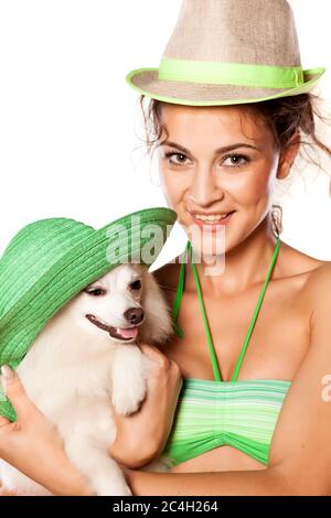 nice girl and little dog posing with hats on white background Stock Photo