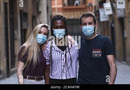 Friends looking at camera wearing medical mask to prevent spread of Covid-19 infection. People need to wear a mask in public places. World pandemic. Stock Photo