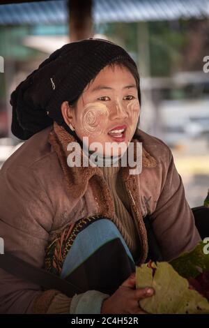 Kayah State, Myanmar - 05 February 2020: Portrait of a young Burmese woman wearing Thanaka,  a yellow cosmetic paste on her cheeks. Stock Photo