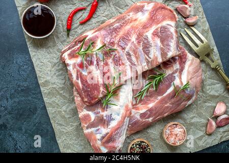 Raw pork ribs with a rosemary and seasoning on crumpled paper Stock Photo