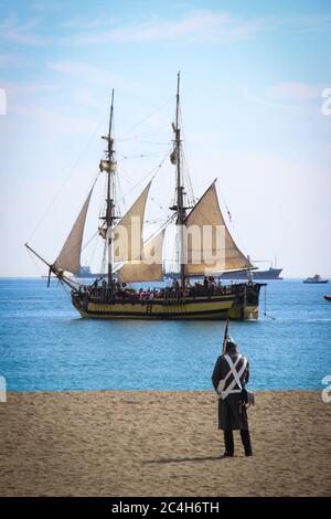 Malaga, Spain - October 26, 2014: Brig La Grace next to the coast. Napoleonic soldier on a beach. Historical reenactment of the British landing of 181 Stock Photo