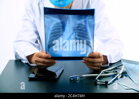 Woman Doctor Looking at X-Ray Radiography in patient's Room, doctor radiology looking x-ray film of patient at hospital. Stock Photo