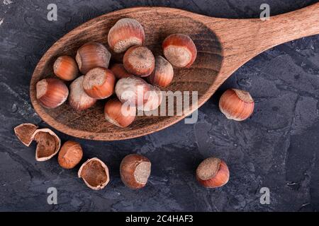 Hazelnuts in a spoon and one broken nut Stock Photo