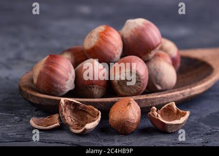 Hazelnuts in a spoon and one broken nut Stock Photo