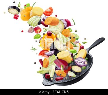 Different vegetables falling into frying pan on white background Stock Photo