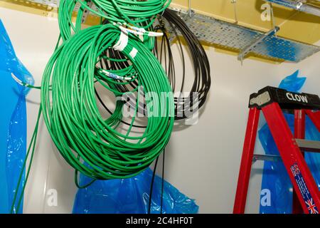 Coils of network cable hang from ceiling in building under construction Stock Photo