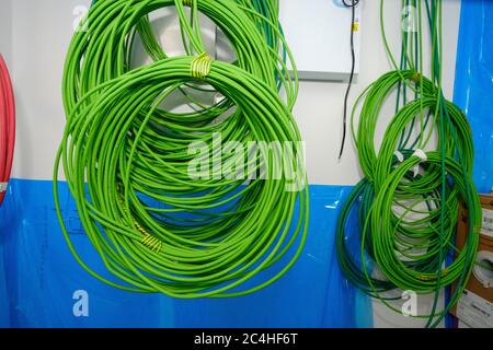 Coils of network cable hang from ceiling in building under construction Stock Photo