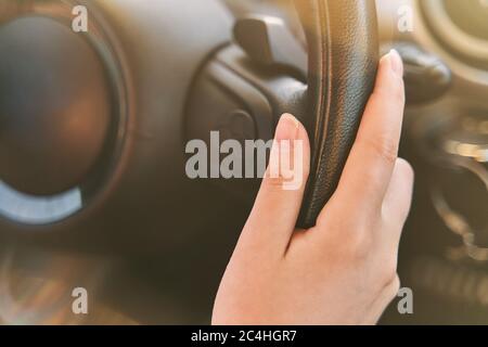 Female hands on the steering wheel of a car while driving. Stock Photo