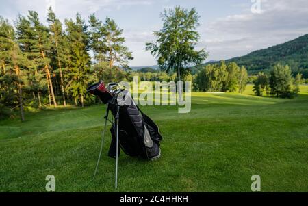 Golf equipment at the course on sunny day. Golf bag on the fairway. Game day Stock Photo