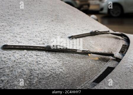 Closeup of wipers and frosted car windshield covered with ice and snow. Winter weather, transportation concept Stock Photo