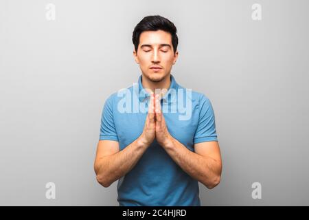 man in blue shirt praying with eyes closed. hope for a better America and kind police Stock Photo