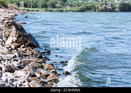 Sea wave on a granite beach in summer Stock Photo