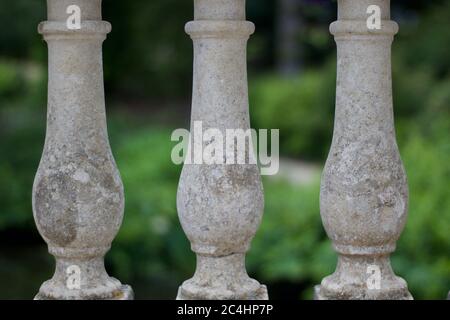 Decorative stone balustrades with blurred green gardens in background Stock Photo