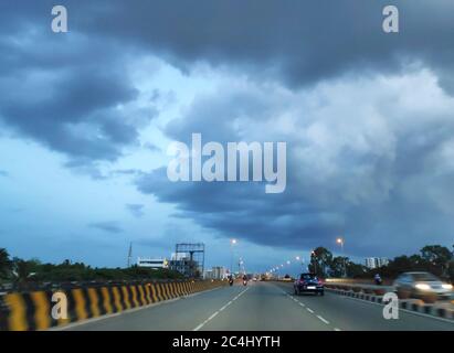 Storm monsoon clouds over a highway at dusk Stock Photo