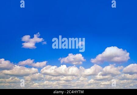 Blue sky, fluffy white clouds, bright sun Stock Photo