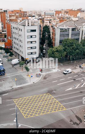 Barcelona, Spain - 15 December 2019: Yellow road marking - a grid with diagonal lines and marked borders, on the road in Barcelona. Road marking in Stock Photo
