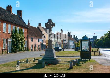 Burnham Market Norfolk, view in summer of the war memorial cross and traditional shops and property on The Green in Burnham Market, north Norfolk, UK. Stock Photo