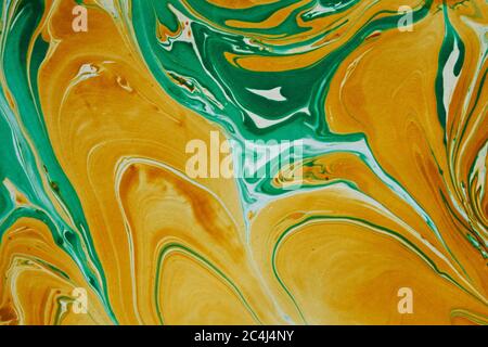 DIY marble background texture abstract pattern wallpaper design in green and gold with swirling paint or pigment in full frame Stock Photo