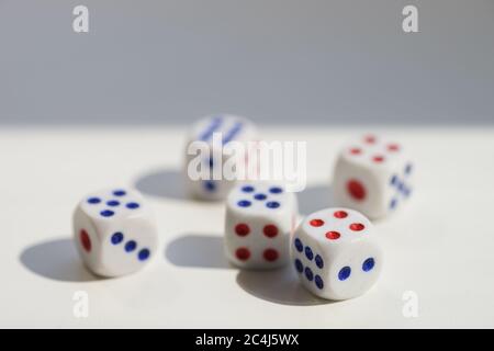 Five dice with different numbers on a white sunny table Stock Photo