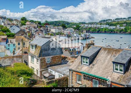 A beautiful coastal scene taken in summer over the roof tops of Polruan Village, Cornwall, England looking across the estuary to the old town of Fowey Stock Photo
