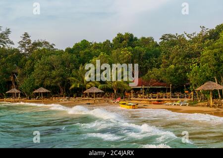 A beautiful beach with umbrellas, beach chairs and boats at the Long Set Beach, Koh Rong, Cambodia Stock Photo