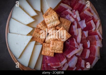 Wood plate with freshly ham, cheese and roasted bread. Healthy food. Spanish food. Stock Photo