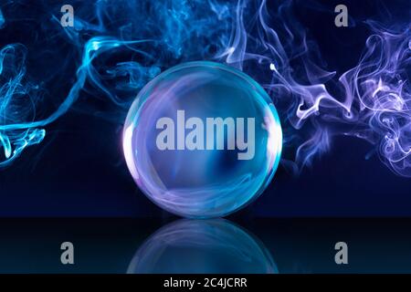 crystal ball in a dark blue smoky background Stock Photo