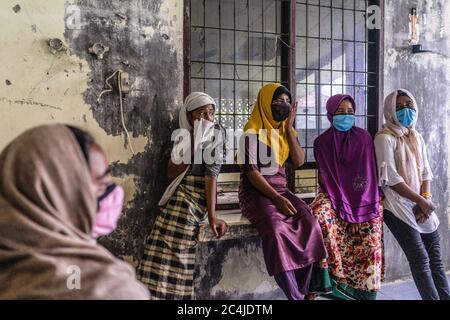 Lhokseumawe, Indonesia. 27th June, 2020. Migrant women look on at a temporary shelter in the immigration detention centre.Dozens of Rohingya people were rescued at sea by Indonesian fishermen while drifting on a broken boat in waters off Seunuddon in North Aceh. Credit: SOPA Images Limited/Alamy Live News Stock Photo