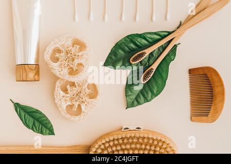 Bamboo toothbrush, toothpaste, natural brush, self-care cosmetics products and white cotton mesh bag on pale background. Zero waste and plastic free c Stock Photo