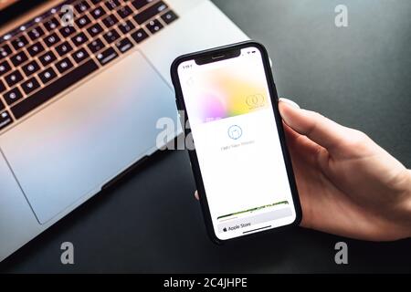Womans hand holding the iPhone X with Apple Card on the screen.  Stock Photo