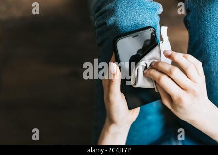 Cleaning the smartphone screen with a fiber cloth from external factors. Stock Photo