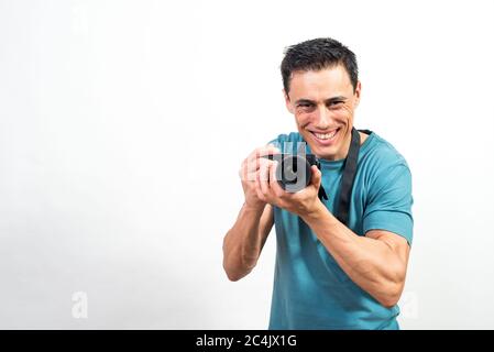Smiling man with a photo camera in hands looking at camera. Mid shot. White background. Stock Photo