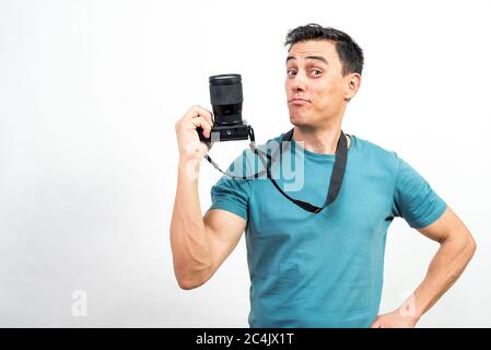 Smiling man showing a photo camera. Mid shot. White background. Stock Photo