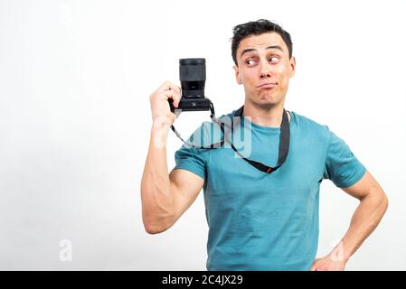 Smiling man showing a photo camera. Mid shot. White background. Stock Photo