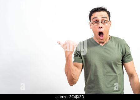 Shocked man with glasses pointing aside. Mid shot. White background. Stock Photo